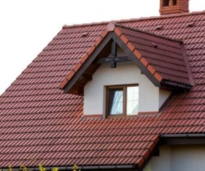 Close up of new orange roof with chimney and small modern window. Concept of modern roof with stylish small brown window.