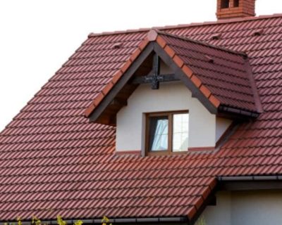 Close up of new orange roof with chimney and small modern window. Concept of modern roof with stylish small brown window.